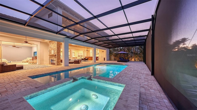 view of pool with a lanai, a patio area, a pool with connected hot tub, and outdoor lounge area