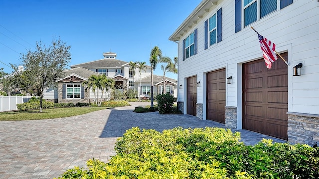 exterior space with a garage and stone siding