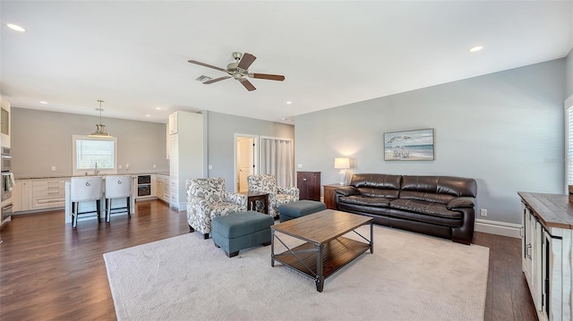 living area with dark wood-style floors, baseboards, and recessed lighting