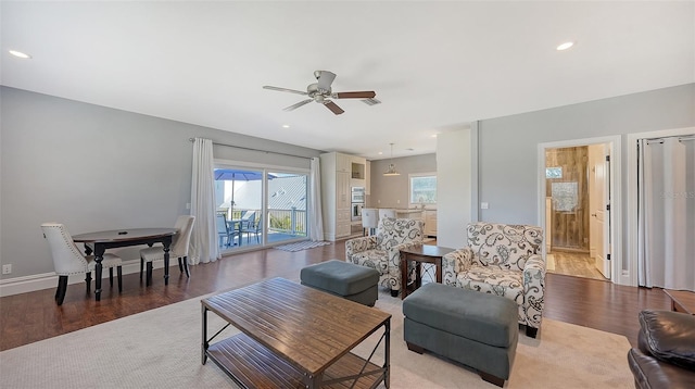 living area with baseboards, ceiling fan, wood finished floors, and recessed lighting