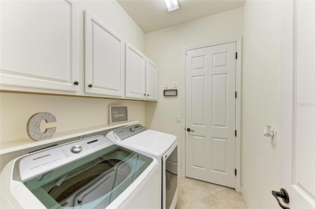 laundry area with cabinet space, washer and clothes dryer, and light tile patterned flooring