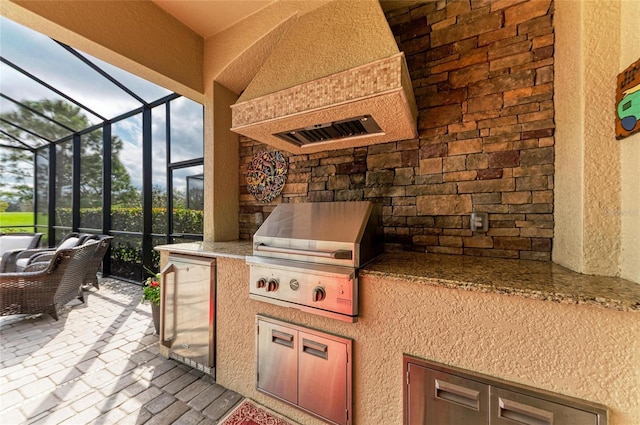 view of patio featuring a lanai, grilling area, and an outdoor kitchen