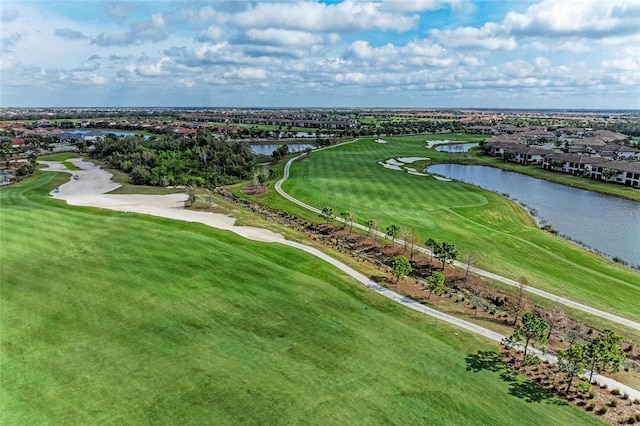 birds eye view of property with golf course view and a water view