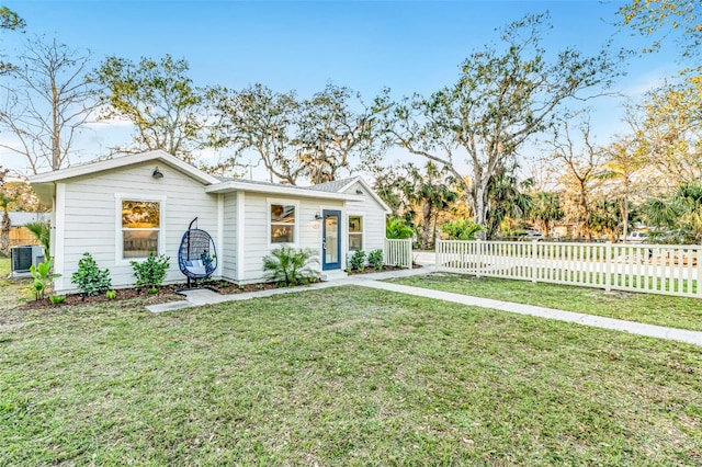 view of front facade with a front yard, fence, and cooling unit