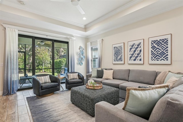 living area with ceiling fan, a tray ceiling, crown molding, and recessed lighting