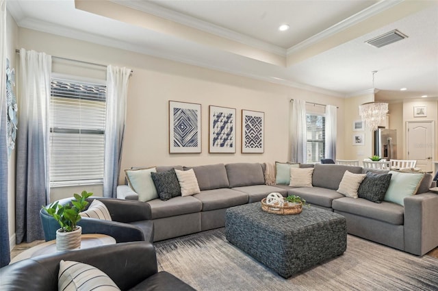 living room with crown molding, visible vents, a tray ceiling, and recessed lighting