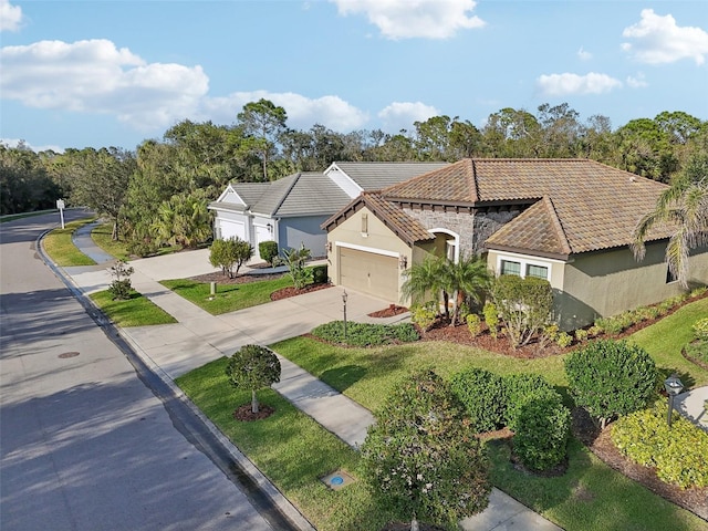 view of front of property with driveway, stucco siding, a garage, and a tiled roof