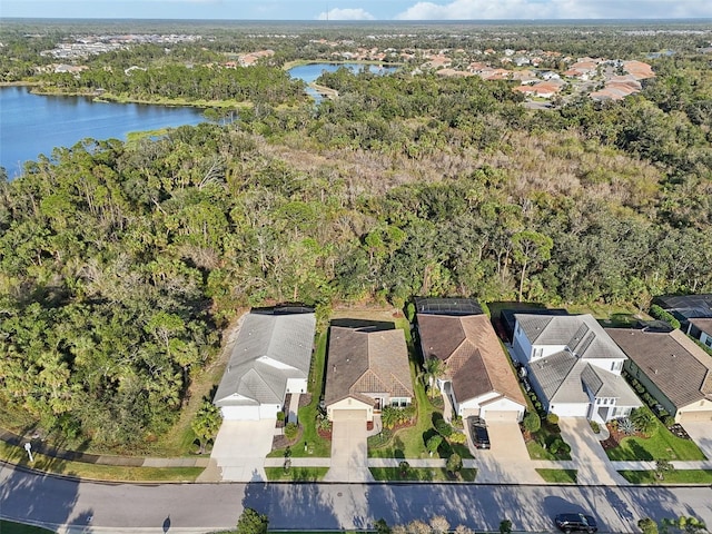 birds eye view of property featuring a residential view, a water view, and a wooded view