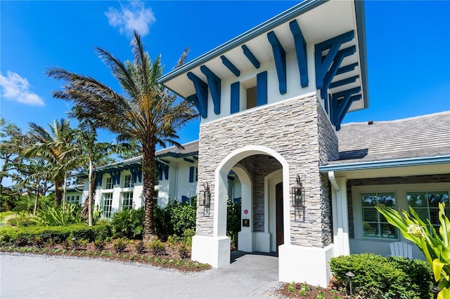 view of exterior entry with stone siding and stucco siding