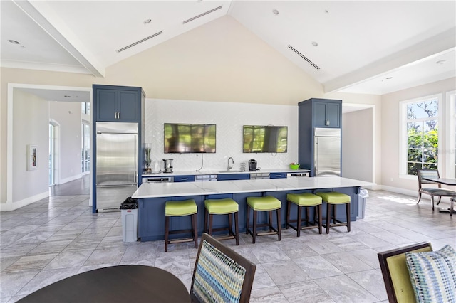 kitchen with built in fridge, a sink, a large island, and a kitchen breakfast bar