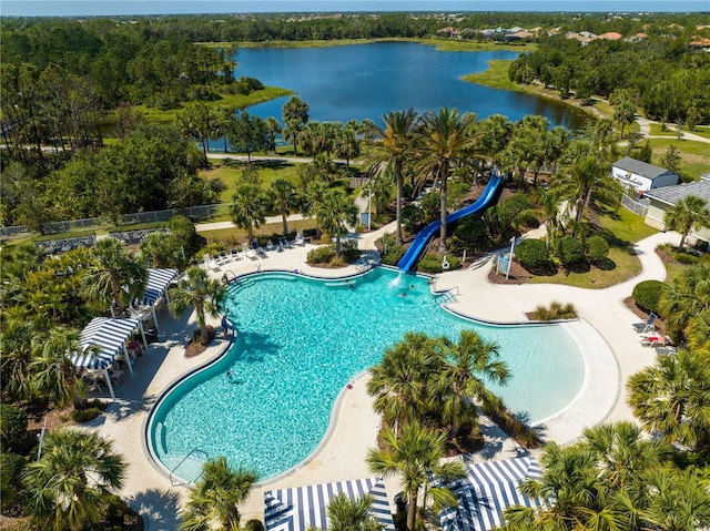 pool with a water view, fence, a water slide, and a patio