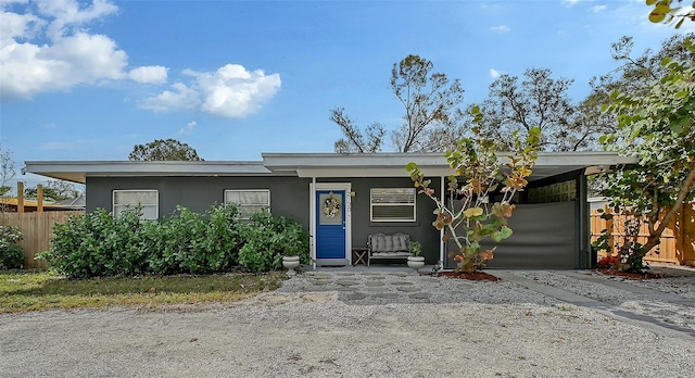 view of front of house with fence and stucco siding