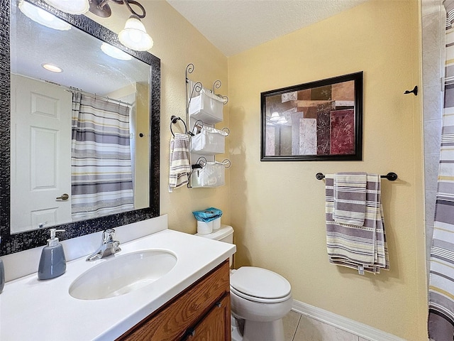 bathroom with baseboards, toilet, tile patterned floors, a textured ceiling, and vanity