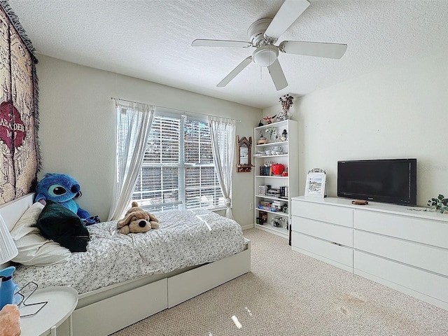 bedroom featuring a textured ceiling, ceiling fan, and light colored carpet