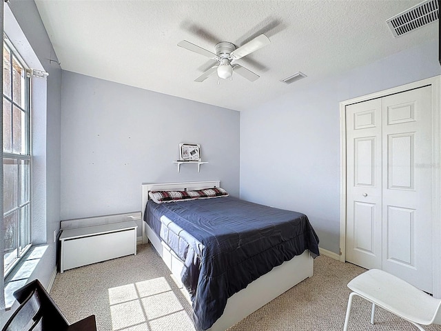 bedroom featuring light carpet, multiple windows, and visible vents