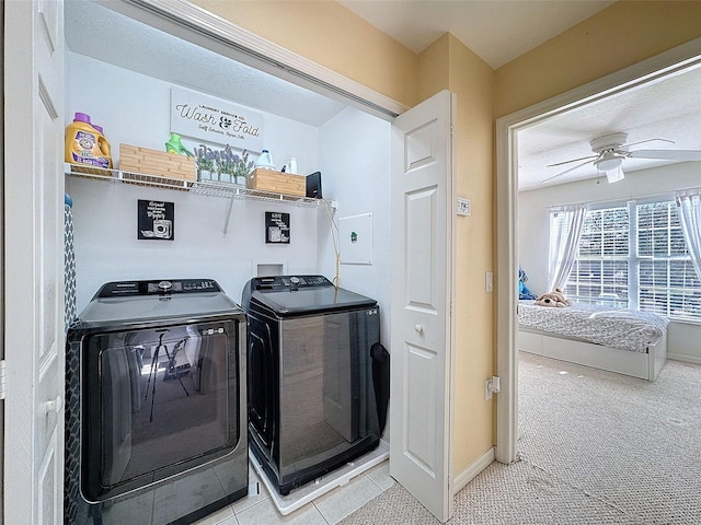 clothes washing area with light carpet, laundry area, a ceiling fan, baseboards, and washer and clothes dryer