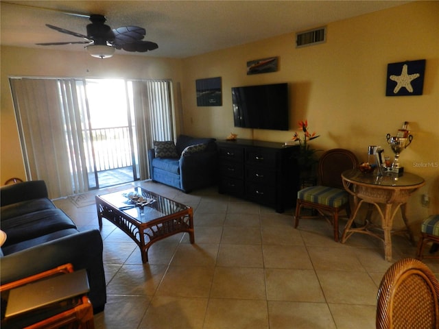 living room featuring light tile patterned floors, ceiling fan, and visible vents