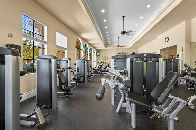 exercise room with ceiling fan, a tray ceiling, recessed lighting, and crown molding