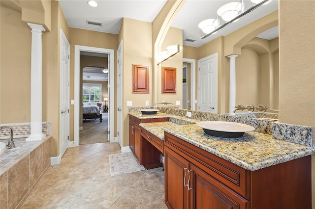 ensuite bathroom featuring visible vents, connected bathroom, tile patterned floors, ornate columns, and a sink