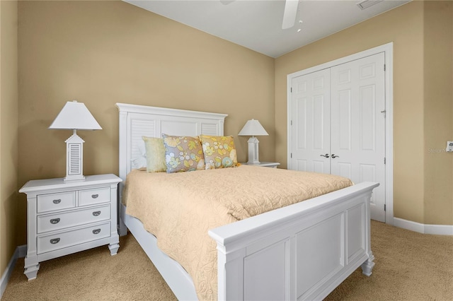 bedroom with a ceiling fan, baseboards, a closet, and light colored carpet