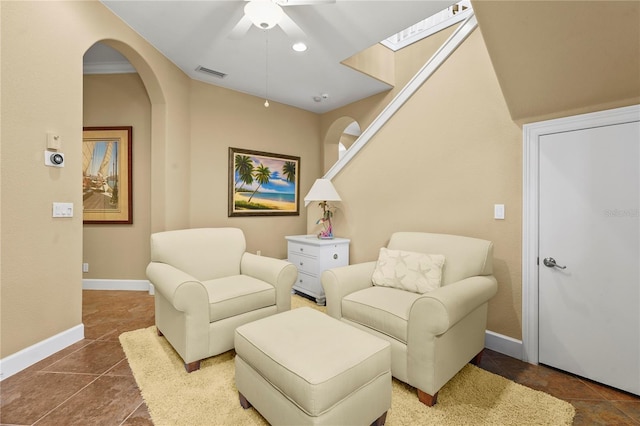 living area with dark tile patterned flooring, visible vents, and baseboards