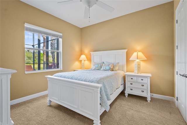 bedroom featuring ceiling fan, baseboards, and light colored carpet