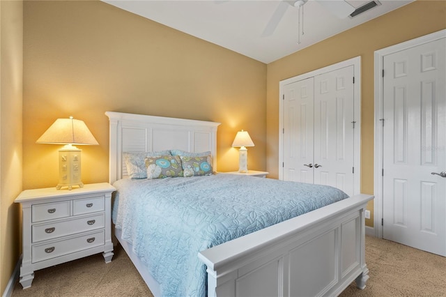 bedroom featuring a closet, visible vents, and light colored carpet