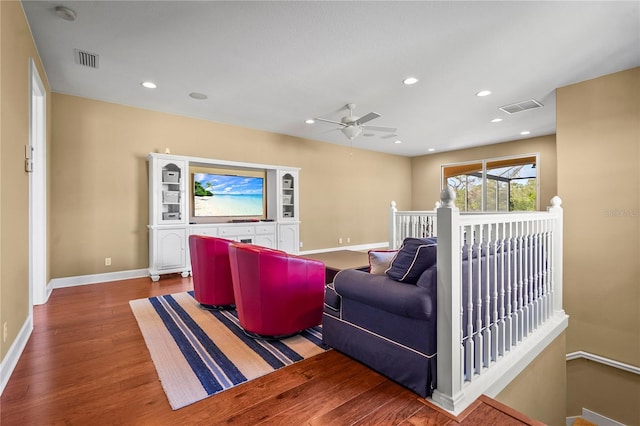 living area with recessed lighting, visible vents, baseboards, and wood finished floors