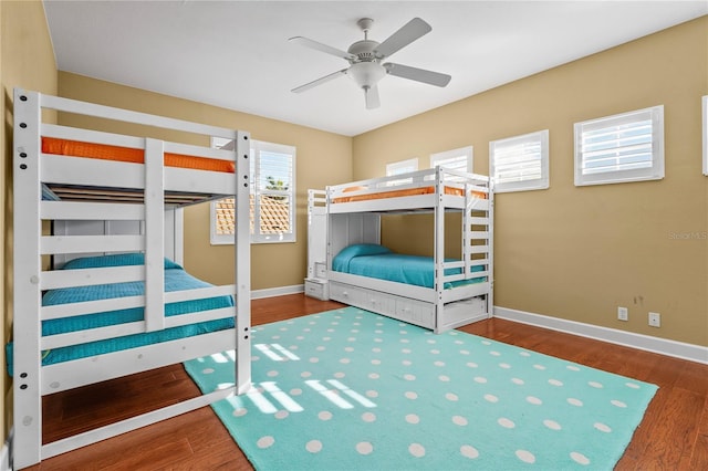 unfurnished bedroom with ceiling fan, baseboards, and wood finished floors