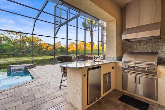 view of patio featuring a sink, a grill, exterior kitchen, a lanai, and an outdoor pool