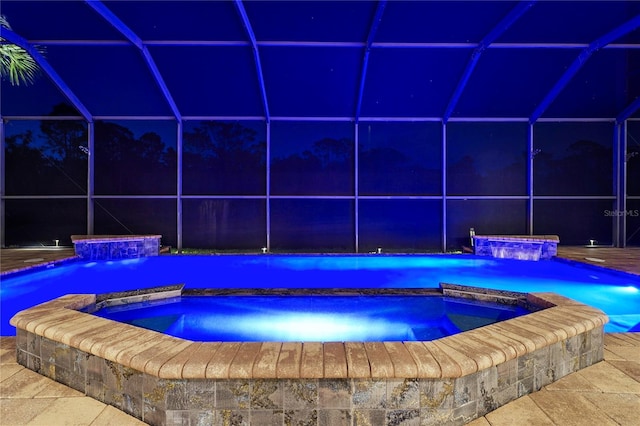 view of pool with glass enclosure and a pool with connected hot tub