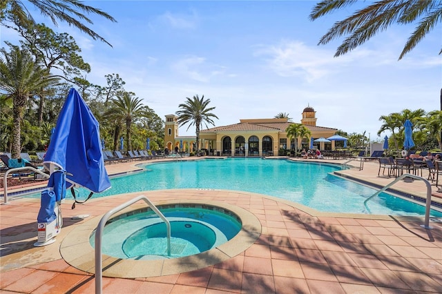 pool featuring a community hot tub and a patio area