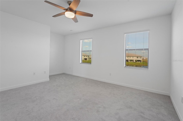 empty room featuring carpet flooring, baseboards, and a ceiling fan