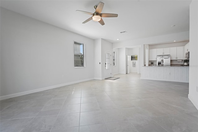 unfurnished living room featuring visible vents, ceiling fan, light tile patterned flooring, and baseboards