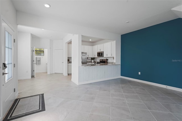 kitchen featuring light tile patterned floors, white cabinetry, recessed lighting, stainless steel appliances, and baseboards