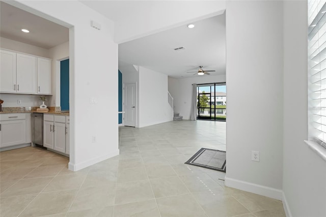 kitchen featuring light tile patterned floors, ceiling fan, white cabinetry, visible vents, and open floor plan