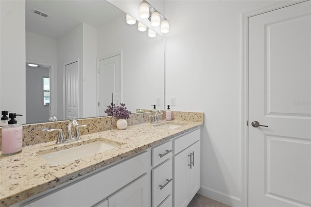 bathroom with a sink, visible vents, double vanity, and tile patterned flooring