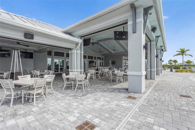 view of patio featuring french doors, outdoor dining space, a ceiling fan, and visible vents