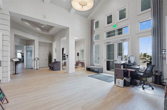 office space with french doors, wood finished floors, high vaulted ceiling, and baseboards