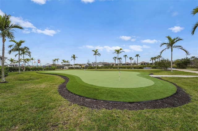 view of community featuring view of golf course and a lawn