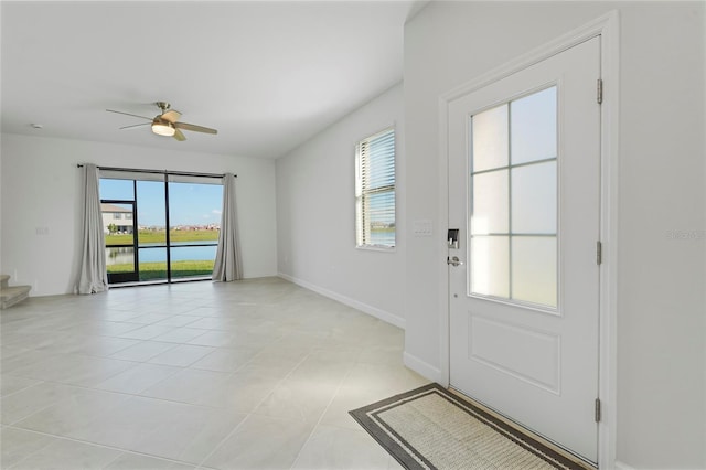 doorway to outside with light tile patterned floors and ceiling fan