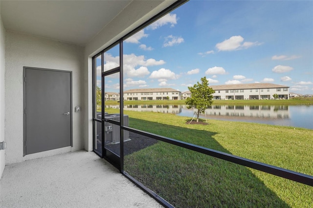 unfurnished sunroom with a water view and a residential view