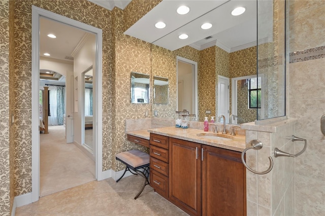 ensuite bathroom with a healthy amount of sunlight, wallpapered walls, ornamental molding, and vanity