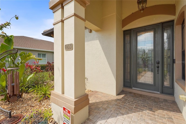 view of exterior entry featuring stucco siding