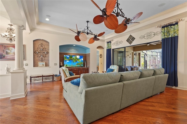 living room with crown molding, a ceiling fan, decorative columns, and hardwood / wood-style flooring