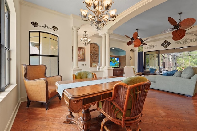 dining area with ceiling fan with notable chandelier, wood-type flooring, arched walkways, and ornate columns