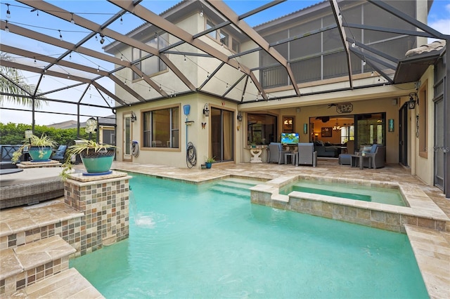 rear view of house featuring a patio, a lanai, a pool with connected hot tub, and stucco siding