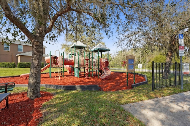 community jungle gym featuring fence and a lawn