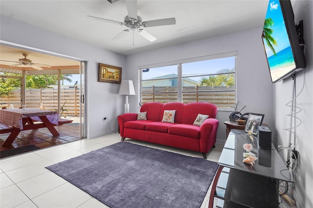 tiled living room featuring a ceiling fan, a healthy amount of sunlight, and baseboards