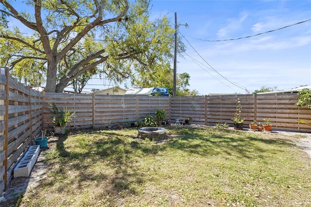 view of yard featuring a fire pit and a fenced backyard